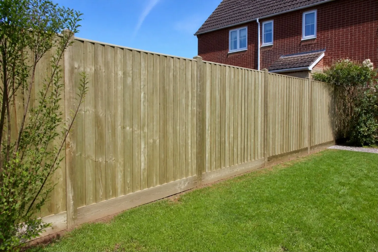 New closeboard timber fence along a lawn behind a red-brick semi-detached house